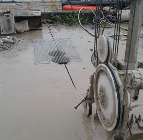 A cut through the reinforced concrete platform produced by the wire saw. In the foreground of the photo the pulleys which drive the diamond wire can be seen